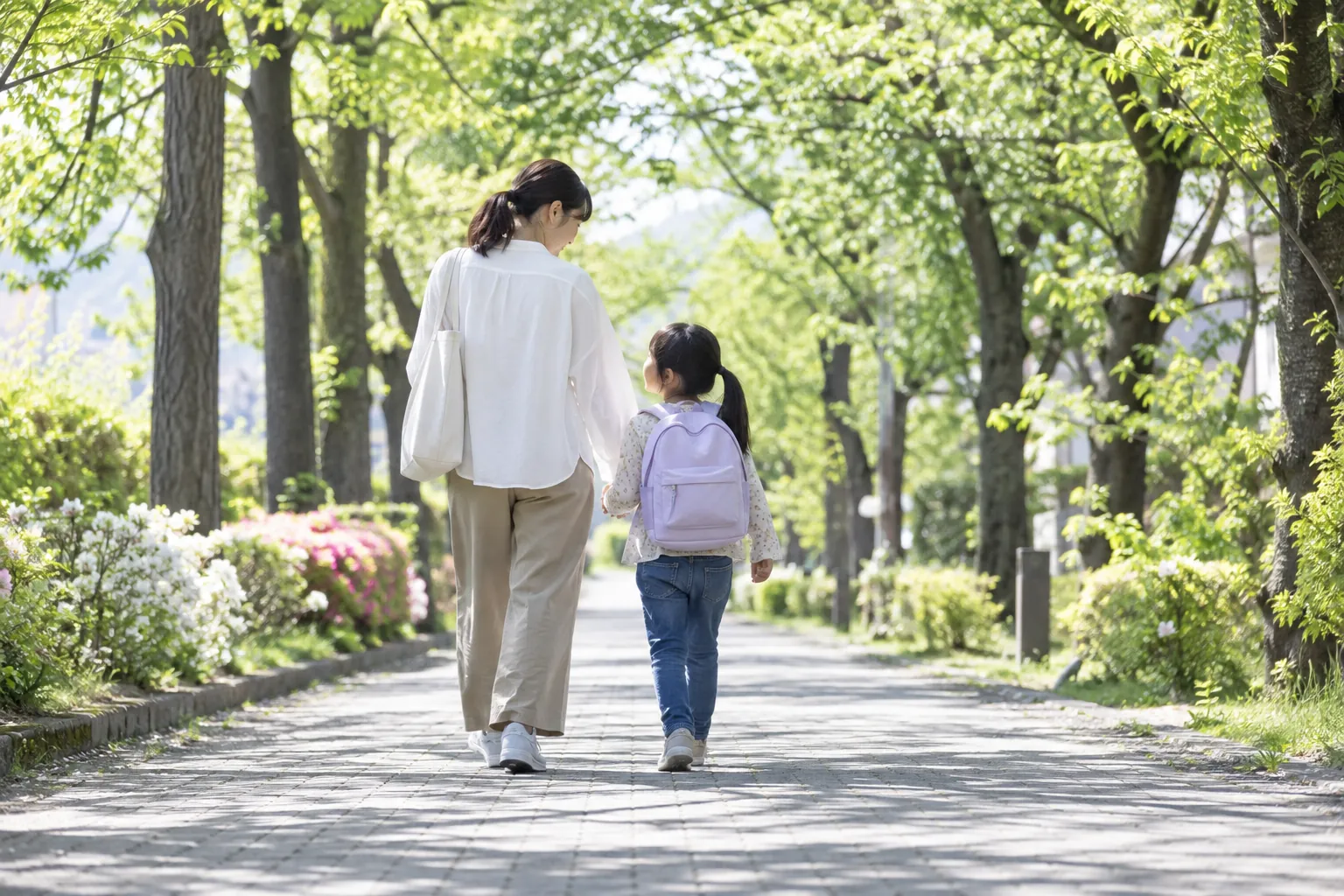 並木道を歩く大人と子ども