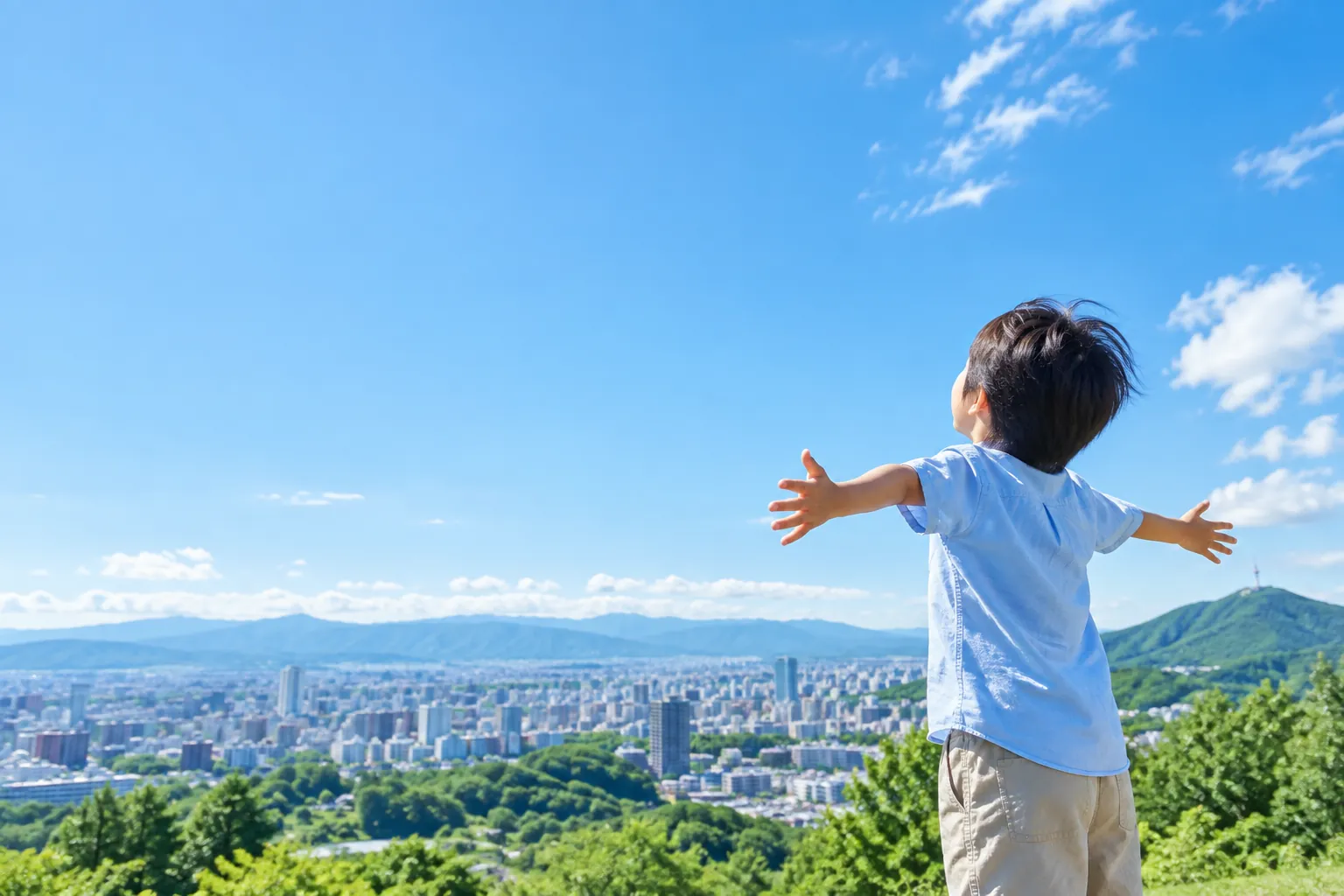 青空を見上げて両手を広げる子ども